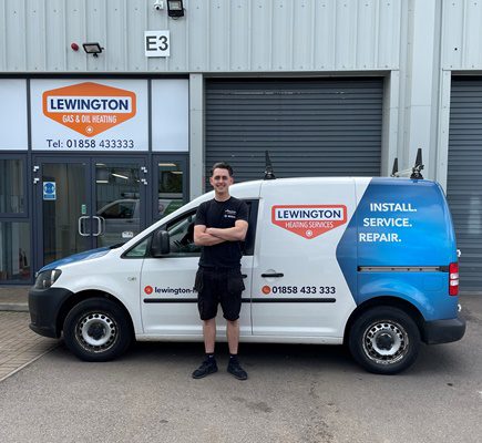 Lewington Heating technician standing beside a branded service van, ready for gas and oil heating installation, service, and repair work.